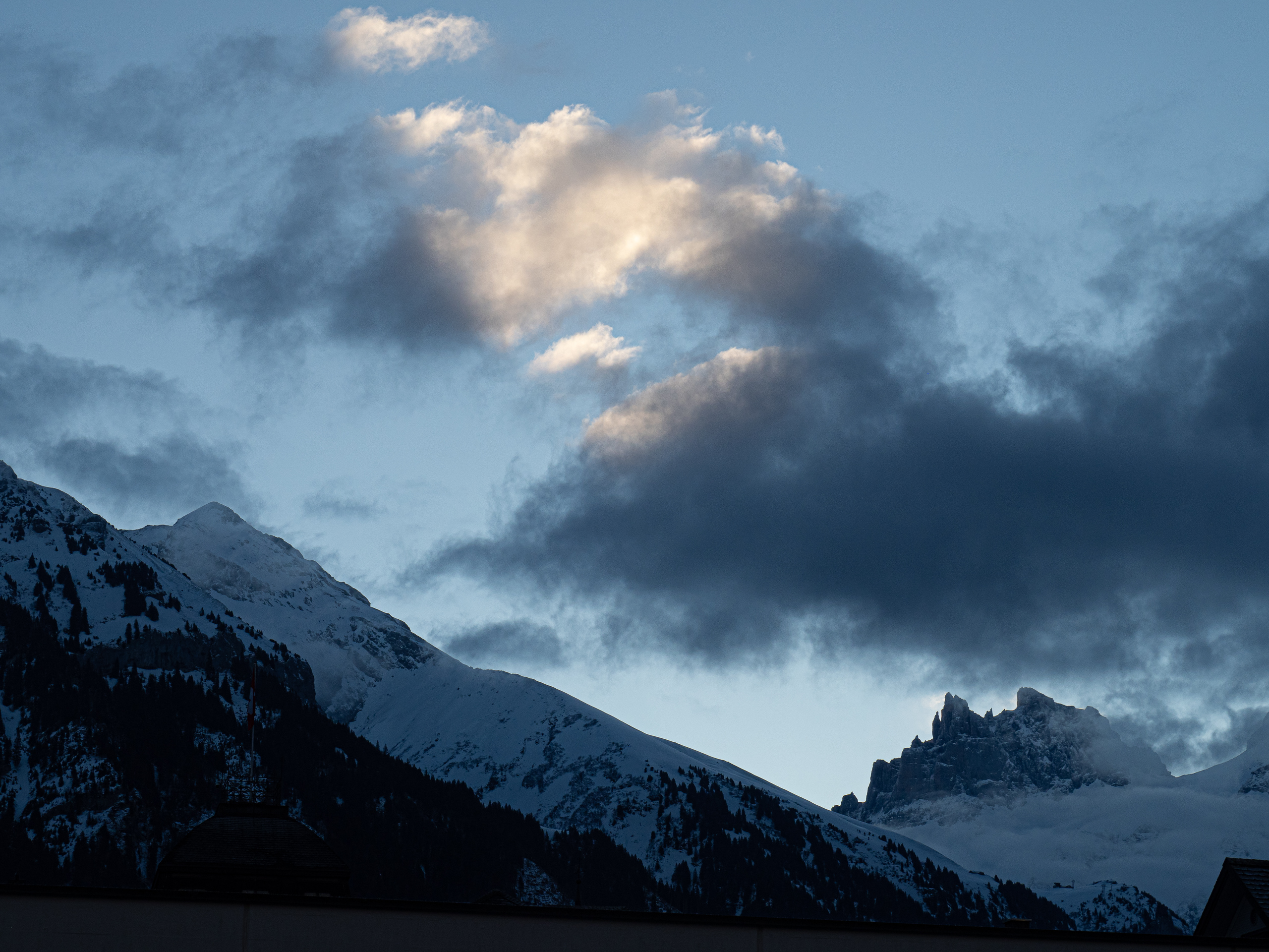 Snow peaks at dusk above an alpine village